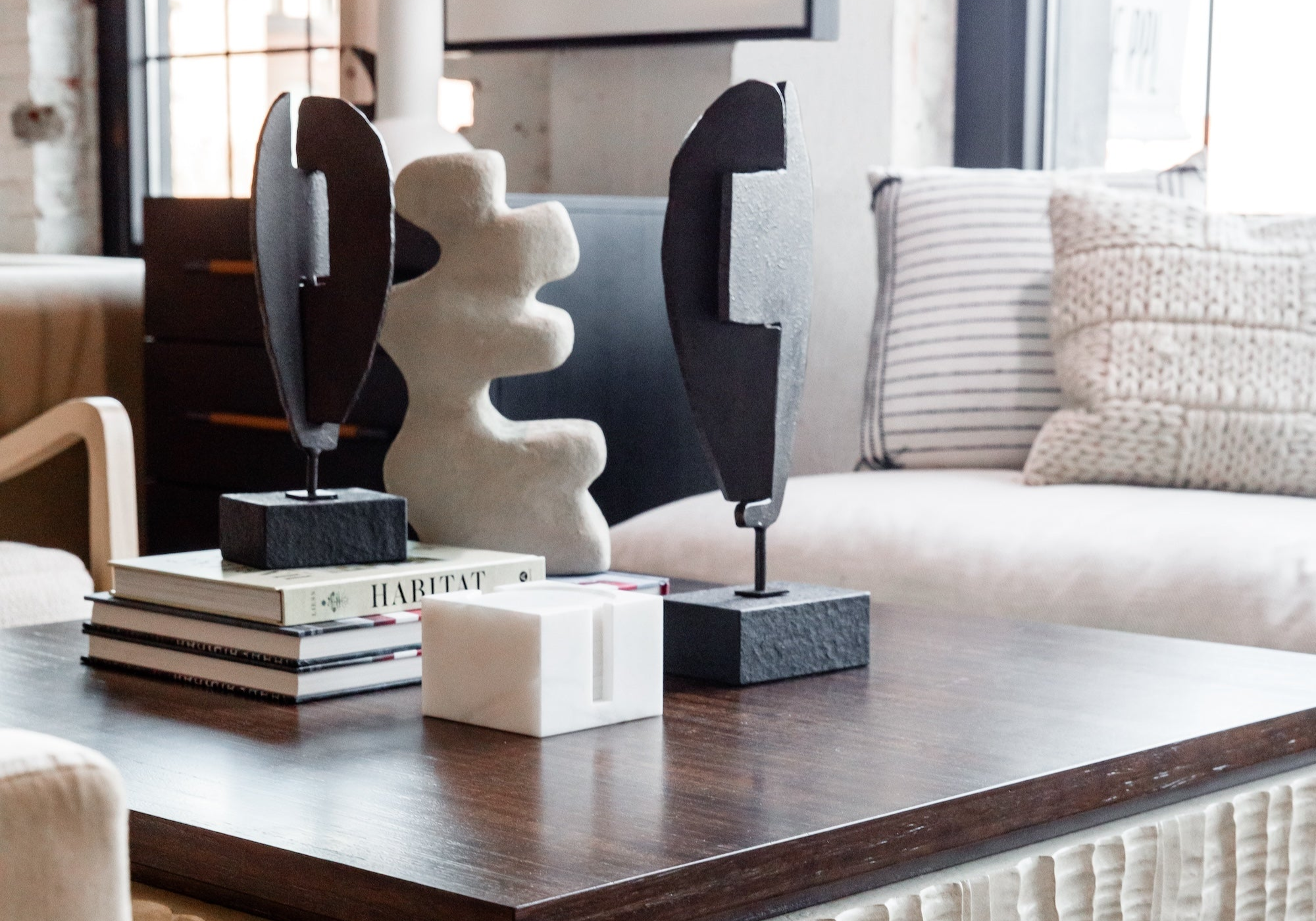 a tight image of a styled coffee table with statues and books