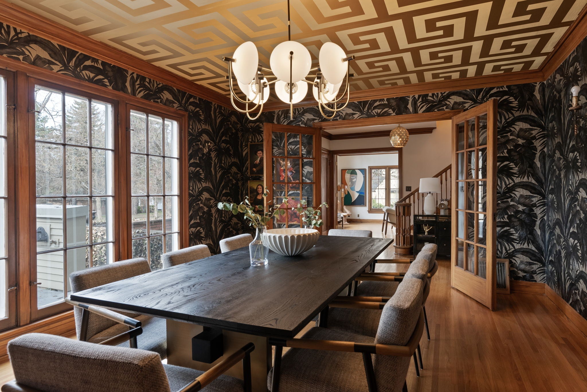 a cool patterned wallpaper and ceiling in a dining room space after day with a designer