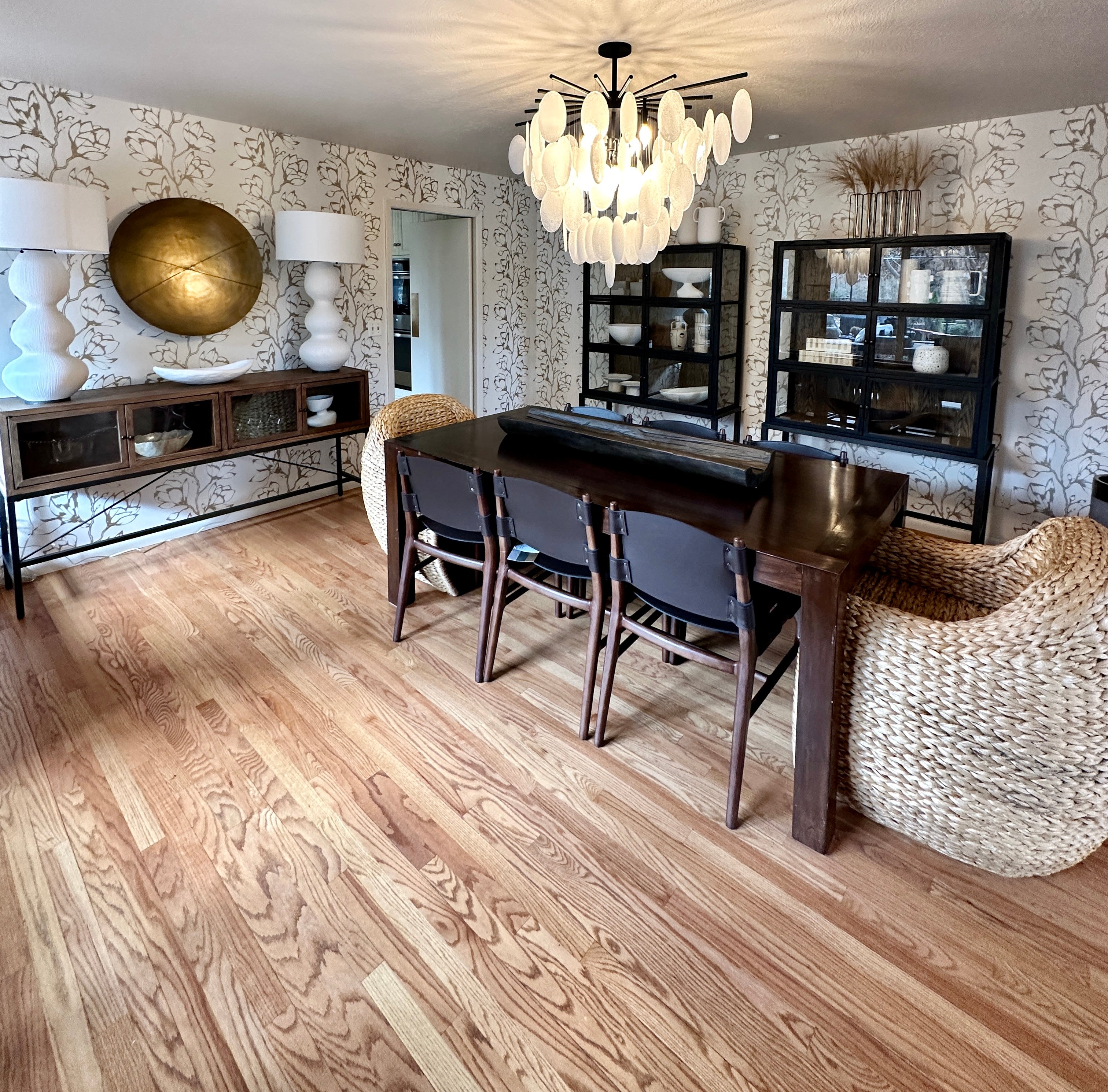 a dining room with cool chandelier and patterned wallpaper after day with a designer